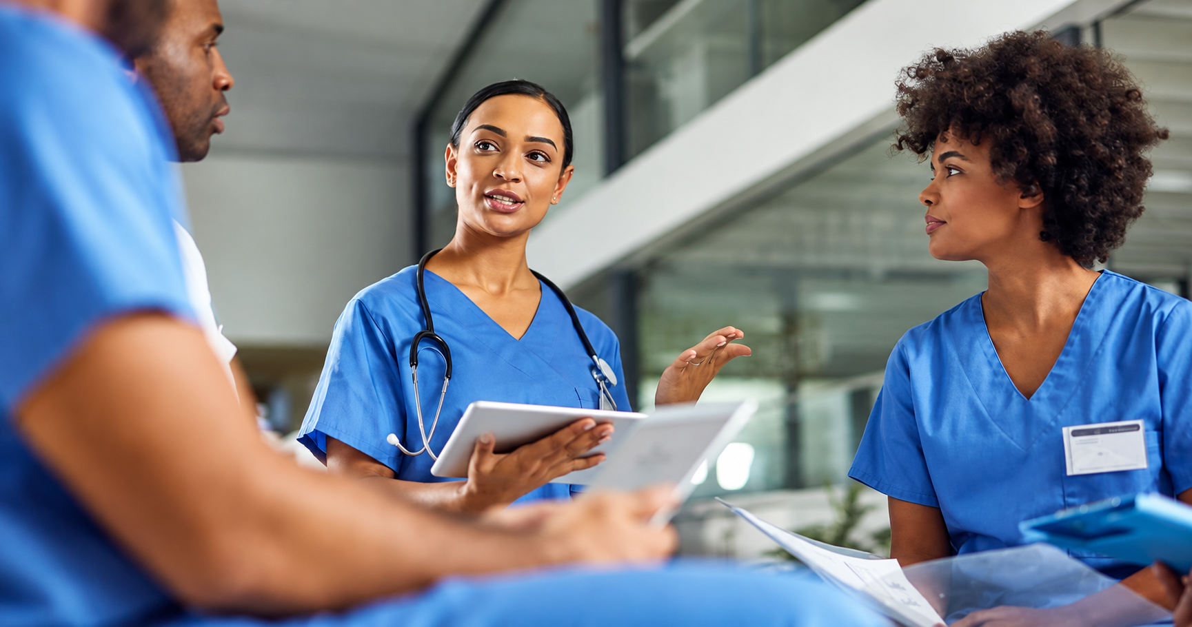 Healthcare professionals discussing a patient care plan during a clinical team handoff.